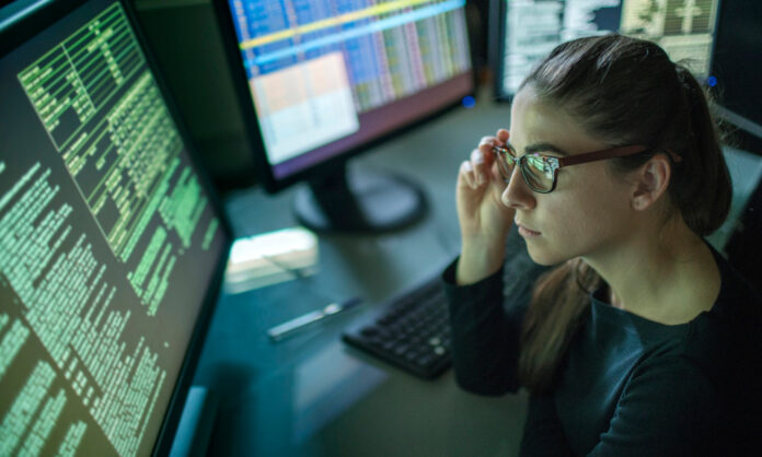 Woman surrounded by monitors