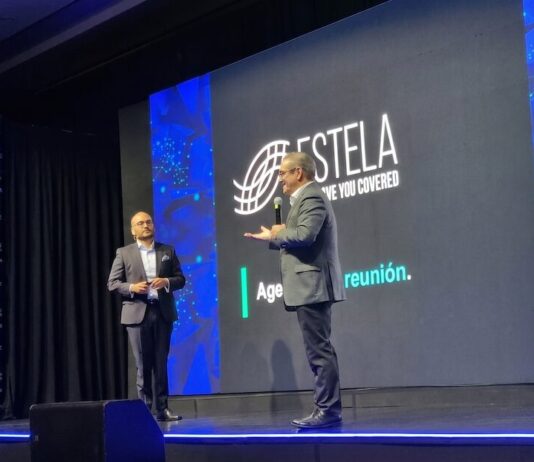 ESTELA: la IA no corrige datos deficientes y puede amplificar los riesgos fiscales de las empresas Fotografía en plano medio de Jair Martínez Aguilar, Country Manager de ESTELA en México, posando de pie y con los brazos cruzados en una oficina corporativa difuminada. El directivo es calvo, tiene barba corta y viste un saco de vestir color azul claro sobre una camisa blanca de cuello abierto. Porta anteojos de armazón negro grueso y mira con expresión seria y fija directamente hacia la cámara. Al fondo se aprecian sutilmente lámparas colgantes modernas de oficina y escritorios de trabajo con personal apenas perceptible.