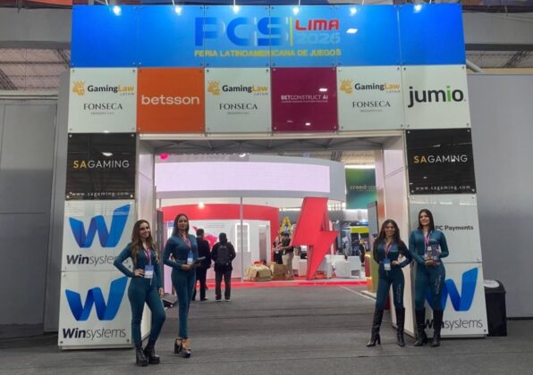 Arco de ingreso oficial a la feria con anfitrionas y logotipos de patrocinadores en PGS Lima 2026.