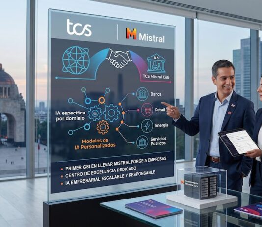 TCS y Mistral llevan la IA empresarial personalizada a una nueva etapa global Fotografía en plano medio de tres profesionales corporativos en trajes oscuros situados dentro de una oficina con una vista panorámica urbana del Monumento a la Revolución en la Ciudad de México a través del ventanal. En la sección izquierda, una pantalla vertical de cristal translúcido muestra diagramas informativos con los logotipos de "TCS" y "Mistral", desglosando sectores como Banca, Retail, Energía y Servicios Públicos bajo el concepto "IA específica por dominio". El ejecutivo central sonríe mientras apunta con su mano hacia la infografía del panel, al tiempo que una de las ejecutivas sostiene una tableta digital. En primer plano, sobre una mesa de vidrio, se aprecian folletos informativos y una pequeña maqueta de un centro de datos dentro de un cubo transparente.