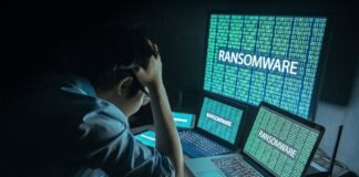 México, entre los países más afectados por el robo de identidad y el ransomware, alerta Sophos Fotografía que muestra a un administrador de TI visto desde atrás, sentado frente a su estación de trabajo en una habitación oscura y sosteniendo su cabeza con ambas manos en un gesto de frustración y estrés. Frente a él, tres pantallas alineadas (una tableta, una computadora portátil en primer plano y un monitor grande al fondo) despliegan simultáneamente código binario de color verde brillante sobre el cual resalta la palabra "RANSOMWARE" en letras mayúsculas blancas, bloqueando el acceso al sistema.