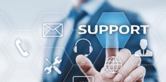 Vulnerabilidades y ransomware elevan el riesgo operativo para industrias estratégicas, advierte Kaseya Ilustración digital en la que un profesional de traje interactúa con una interfaz futurista de hexágonos flotantes. Su dedo índice presiona el botón azul con la palabra "SUPPORT", rodeado de iconos tecnológicos como un sobre de correo, un teléfono, herramientas de mantenimiento, unos auriculares con micrófono, un globo terráqueo, un globo de texto y la silueta de una persona.