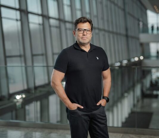 TOTVS destaca que la revisión del T-MEC impulsa la transformación digital de las empresas mexicanas Fotografía de Ivaldo Pereira, Head de TOTVS México, posando de frente con las manos en los bolsillos dentro de un moderno edificio corporativo con amplios ventanales de cristal. El ejecutivo usa anteojos, un reloj de pulsera oscuro y viste una playera tipo polo color negro.