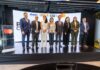 AMITI presenta “PyMEs Ciberseguras” para fortalecer la protección digital de empresas mexicanas Fotografía frontal de un grupo de ocho personas, conformado por hombres y mujeres en vestimenta formal de negocios, posando de pie y sonriendo sobre un escenario. A la izquierda del grupo hay un podio transparente que muestra el logotipo de Mastercard. En la parte trasera, una gran pantalla curva iluminada exhibe parte del texto del evento y los logotipos oficiales de AMITI, Capa 8, KIO IT Services y Mastercard.