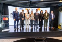 AMITI presenta “PyMEs Ciberseguras” para fortalecer la protección digital de empresas mexicanas Fotografía frontal de un grupo de ocho personas, conformado por hombres y mujeres en vestimenta formal de negocios, posando de pie y sonriendo sobre un escenario. A la izquierda del grupo hay un podio transparente que muestra el logotipo de Mastercard. En la parte trasera, una gran pantalla curva iluminada exhibe parte del texto del evento y los logotipos oficiales de AMITI, Capa 8, KIO IT Services y Mastercard.