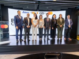 AMITI presenta “PyMEs Ciberseguras” para fortalecer la protección digital de empresas mexicanas Fotografía frontal de un grupo de ocho personas, conformado por hombres y mujeres en vestimenta formal de negocios, posando de pie y sonriendo sobre un escenario. A la izquierda del grupo hay un podio transparente que muestra el logotipo de Mastercard. En la parte trasera, una gran pantalla curva iluminada exhibe parte del texto del evento y los logotipos oficiales de AMITI, Capa 8, KIO IT Services y Mastercard.