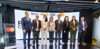 AMITI presenta “PyMEs Ciberseguras” para fortalecer la protección digital de empresas mexicanas Fotografía frontal de un grupo de ocho personas, conformado por hombres y mujeres en vestimenta formal de negocios, posando de pie y sonriendo sobre un escenario. A la izquierda del grupo hay un podio transparente que muestra el logotipo de Mastercard. En la parte trasera, una gran pantalla curva iluminada exhibe parte del texto del evento y los logotipos oficiales de AMITI, Capa 8, KIO IT Services y Mastercard.