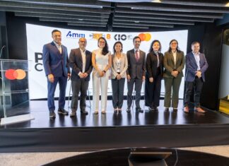 AMITI presenta “PyMEs Ciberseguras” para fortalecer la protección digital de empresas mexicanas Fotografía frontal de un grupo de ocho personas, conformado por hombres y mujeres en vestimenta formal de negocios, posando de pie y sonriendo sobre un escenario. A la izquierda del grupo hay un podio transparente que muestra el logotipo de Mastercard. En la parte trasera, una gran pantalla curva iluminada exhibe parte del texto del evento y los logotipos oficiales de AMITI, Capa 8, KIO IT Services y Mastercard.