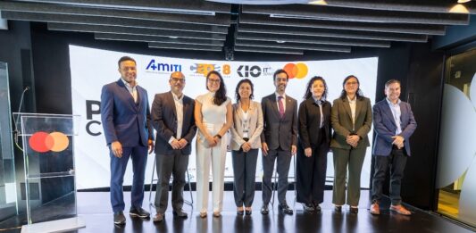 AMITI presenta “PyMEs Ciberseguras” para fortalecer la protección digital de empresas mexicanas Fotografía frontal de un grupo de ocho personas, conformado por hombres y mujeres en vestimenta formal de negocios, posando de pie y sonriendo sobre un escenario. A la izquierda del grupo hay un podio transparente que muestra el logotipo de Mastercard. En la parte trasera, una gran pantalla curva iluminada exhibe parte del texto del evento y los logotipos oficiales de AMITI, Capa 8, KIO IT Services y Mastercard.