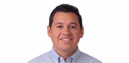 Hikvision impulsa una estrategia inteligente para la infraestructura crítica Fotografía de retrato de Xavier Arroyo, hombre de tez clara, cabello oscuro y corto, sonriendo directamente a la cámara. Viste una camisa de botones en tono azul claro y se encuentra sobre un fondo completamente blanco.