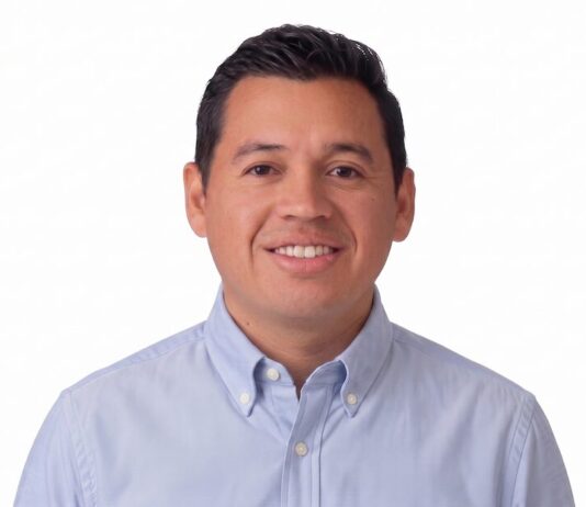 Hikvision impulsa una estrategia inteligente para la infraestructura crítica Fotografía de retrato de Xavier Arroyo, hombre de tez clara, cabello oscuro y corto, sonriendo directamente a la cámara. Viste una camisa de botones en tono azul claro y se encuentra sobre un fondo completamente blanco.