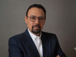 Tanium advierte que la IA acelera los ciberataques y exige respuestas en tiempo real Fotografía de retrato de Jorge López, un hombre con barba candado, gafas de montura fina y traje oscuro con camisa blanca, mirando directamente a la cámara sobre un fondo gris neutro.