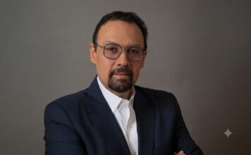 Tanium advierte que la IA acelera los ciberataques y exige respuestas en tiempo real Fotografía de retrato de Jorge López, un hombre con barba candado, gafas de montura fina y traje oscuro con camisa blanca, mirando directamente a la cámara sobre un fondo gris neutro.