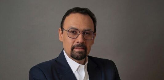 Tanium advierte que la IA acelera los ciberataques y exige respuestas en tiempo real Fotografía de retrato de Jorge López, un hombre con barba candado, gafas de montura fina y traje oscuro con camisa blanca, mirando directamente a la cámara sobre un fondo gris neutro.