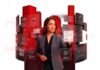 Getnet México transforma los pagos en motor de crecimiento empresarial Fotografía de una mujer con traje sastre gris interactuando con una interfaz holográfica que despliega paneles interactivos con opciones como "Cobro con tarjeta", "Pago sin contacto", "Comercio electrónico" y "Analítica". Al fondo se observan formas geométricas cilíndricas de color rojo brillante sobre un fondo blanco.