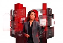 Getnet México transforma los pagos en motor de crecimiento empresarial Fotografía de una mujer con traje sastre gris interactuando con una interfaz holográfica que despliega paneles interactivos con opciones como "Cobro con tarjeta", "Pago sin contacto", "Comercio electrónico" y "Analítica". Al fondo se observan formas geométricas cilíndricas de color rojo brillante sobre un fondo blanco.
