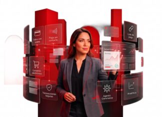 Getnet México transforma los pagos en motor de crecimiento empresarial Fotografía de una mujer con traje sastre gris interactuando con una interfaz holográfica que despliega paneles interactivos con opciones como "Cobro con tarjeta", "Pago sin contacto", "Comercio electrónico" y "Analítica". Al fondo se observan formas geométricas cilíndricas de color rojo brillante sobre un fondo blanco.