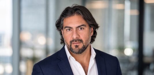 Streambe y la ejecución de IA empresarial en México: cómo convertir innovación y datos en impacto real de negocio Retrato corporativo de Fernando Aldana posando en primer plano con saco azul marino sobre una camisa blanca. Se encuentra mirando fijamente a la cámara con una expresión seria y profesional dentro de un espacio de oficinas bien iluminado.