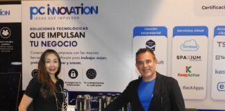 PC Innovation y la revolución tecnológica que redefine el sector enterprise Fotografía en plano medio de Nadia González y Eleazar Carrillo posando juntos detrás del mostrador corporativo de PC Innovation en un evento de la industria tecnológica.