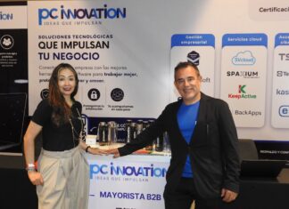 PC Software y la revolución tecnológica que redefine el sector enterprise Fotografía en plano medio de Nadia González y Eleazar Carrillo posando juntos detrás del mostrador corporativo de PC Innovation en un evento de la industria tecnológica.