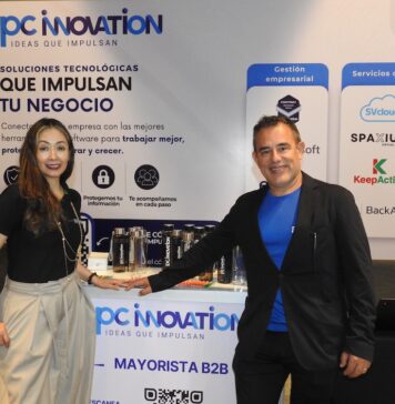 PC Innovation y la revolución tecnológica que redefine el sector enterprise Fotografía en plano medio de Nadia González y Eleazar Carrillo posando juntos detrás del mostrador corporativo de PC Innovation en un evento de la industria tecnológica.