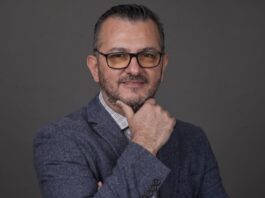 EPAM NEORIS: En la industria cementera, ese costo se refleja en accidentes, paros de planta e inventario perdido Fotografía de retrato en plano medio de Gilberto Quintanilla, Director Asociado y Líder de Visión por Computadora en EPAM NEORIS, vistiendo atuendo ejecutivo y posando en un entorno corporativo.
