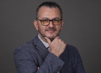EPAM NEORIS: En la industria cementera, ese costo se refleja en accidentes, paros de planta e inventario perdido Fotografía de retrato en plano medio de Gilberto Quintanilla, Director Asociado y Líder de Visión por Computadora en EPAM NEORIS, vistiendo atuendo ejecutivo y posando en un entorno corporativo.