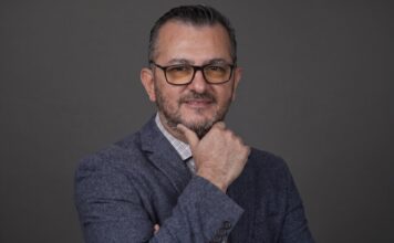 EPAM NEORIS: En la industria cementera, ese costo se refleja en accidentes, paros de planta e inventario perdido Fotografía de retrato en plano medio de Gilberto Quintanilla, Director Asociado y Líder de Visión por Computadora en EPAM NEORIS, vistiendo atuendo ejecutivo y posando en un entorno corporativo.