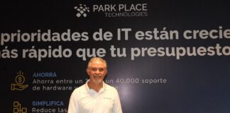 El salvavidas del centro de datos corporativo se llama Park Place y redefine la inversión tecnológica Fotografía en plano medio de Rogelio Moncada, Director Comercial para North Latam en Park Place Technologies, vistiendo camisa blanca tipo polo corporativa, posando sonriente frente a un muro publicitario con la frase "Las prioridades de IT están creciendo más rápido que tu presupuesto".