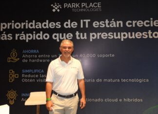 El salvavidas del centro de datos corporativo se llama Park Place y redefine la inversión tecnológica Fotografía en plano medio de Rogelio Moncada, Director Comercial para North Latam en Park Place Technologies, vistiendo camisa blanca tipo polo corporativa, posando sonriente frente a un muro publicitario con la frase "Las prioridades de IT están creciendo más rápido que tu presupuesto".