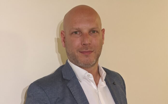 Sebastián Osterc impulsa la convergencia tecnológica y la seguridad crítica para el sector energético Fotografía de retrato en plano medio de Sebastián Osterc, Channel Sales Manager para Argentina, Paraguay, Uruguay y Bolivia en Motorola Solutions, vistiendo saco azul sobre camisa blanca de vestir, posando frente a un fondo claro.